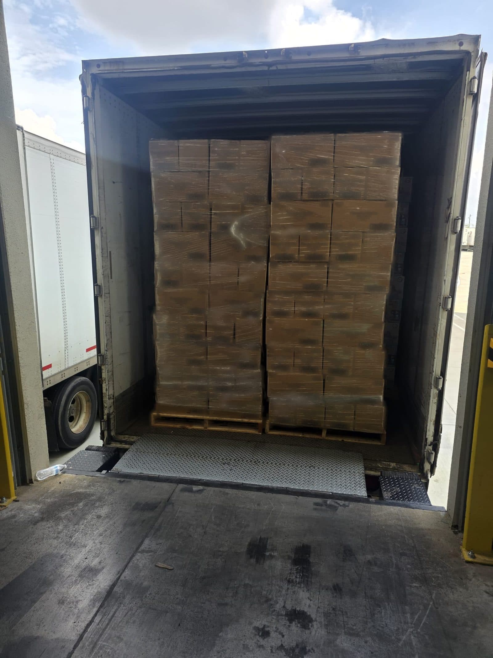 A full trailer of boxed freight on pallets at the dock