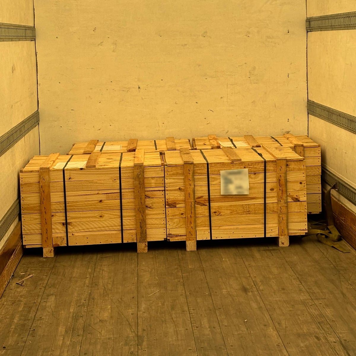 Un huacal de madera sobre tarima dentro de un camión de caja