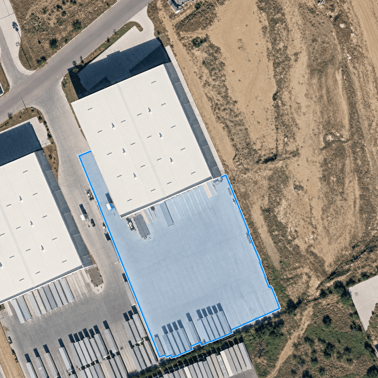 Aerial view of the Distrubi trailer parking and drop yard in Laredo, TX, outlined in blue, part of the 100,000 sq ft warehouse property